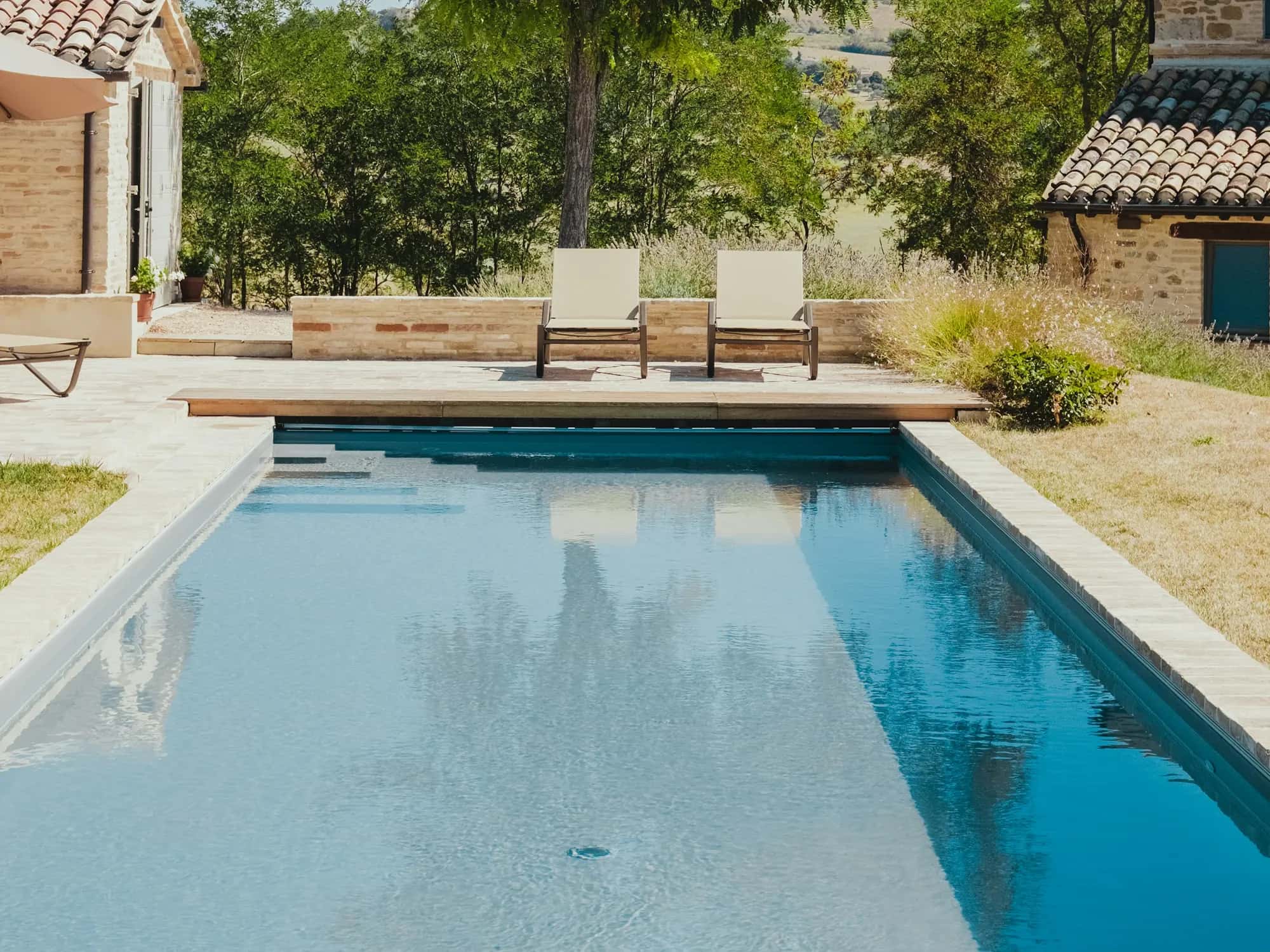 Piscina larga junto a una casa de piedra
