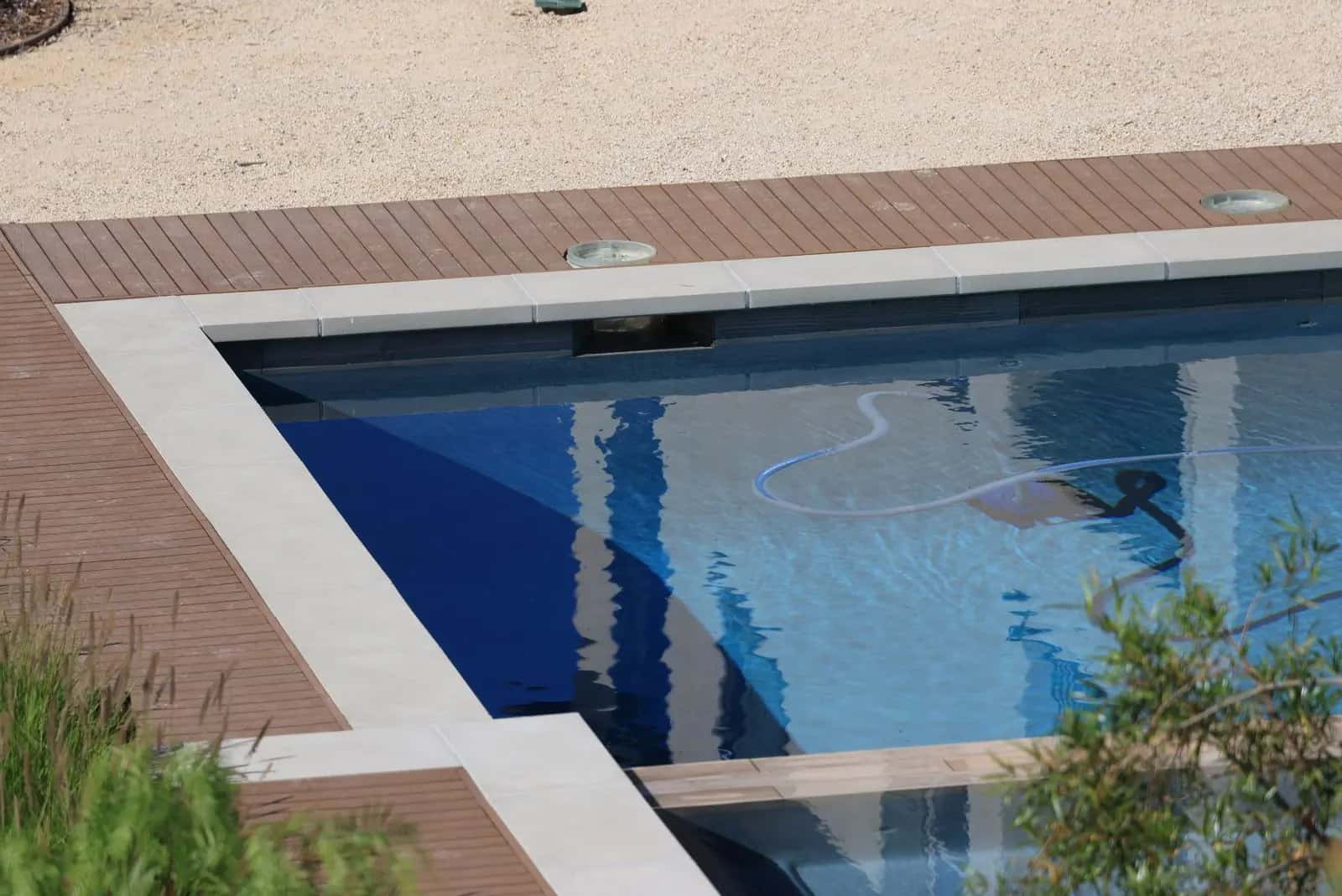 Piscina con la manguera del limpiafondos